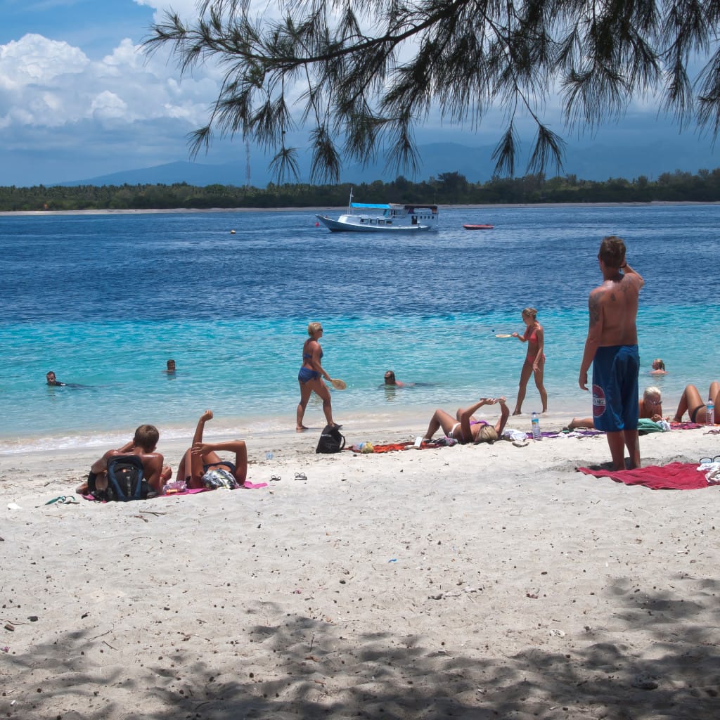 personas tomando sol en la playa, exposición solar acumulada que origina la queratosis actínica